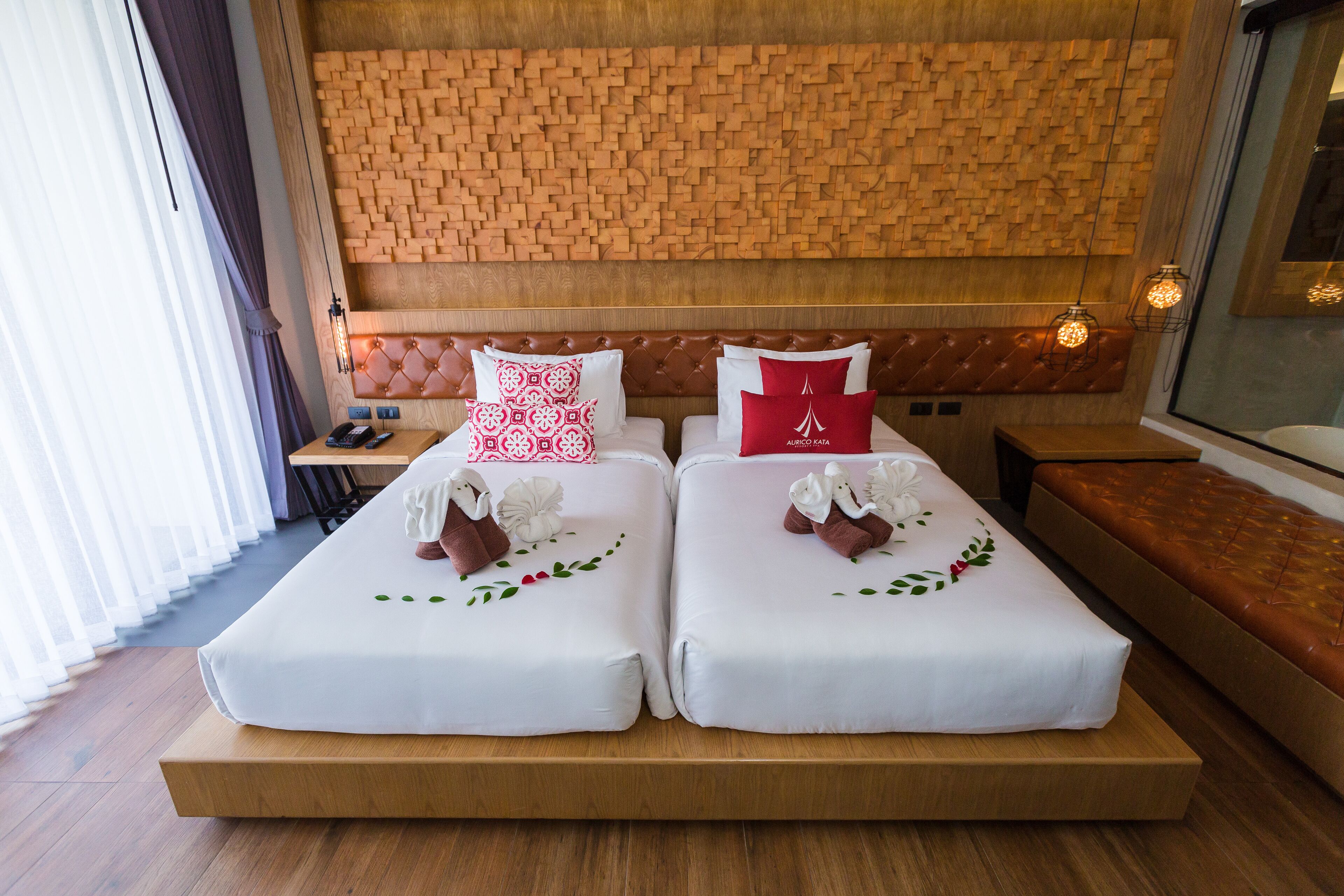 Une chambre d’hôtel avec deux lits, une tête de lit en bois et un plancher en bois.