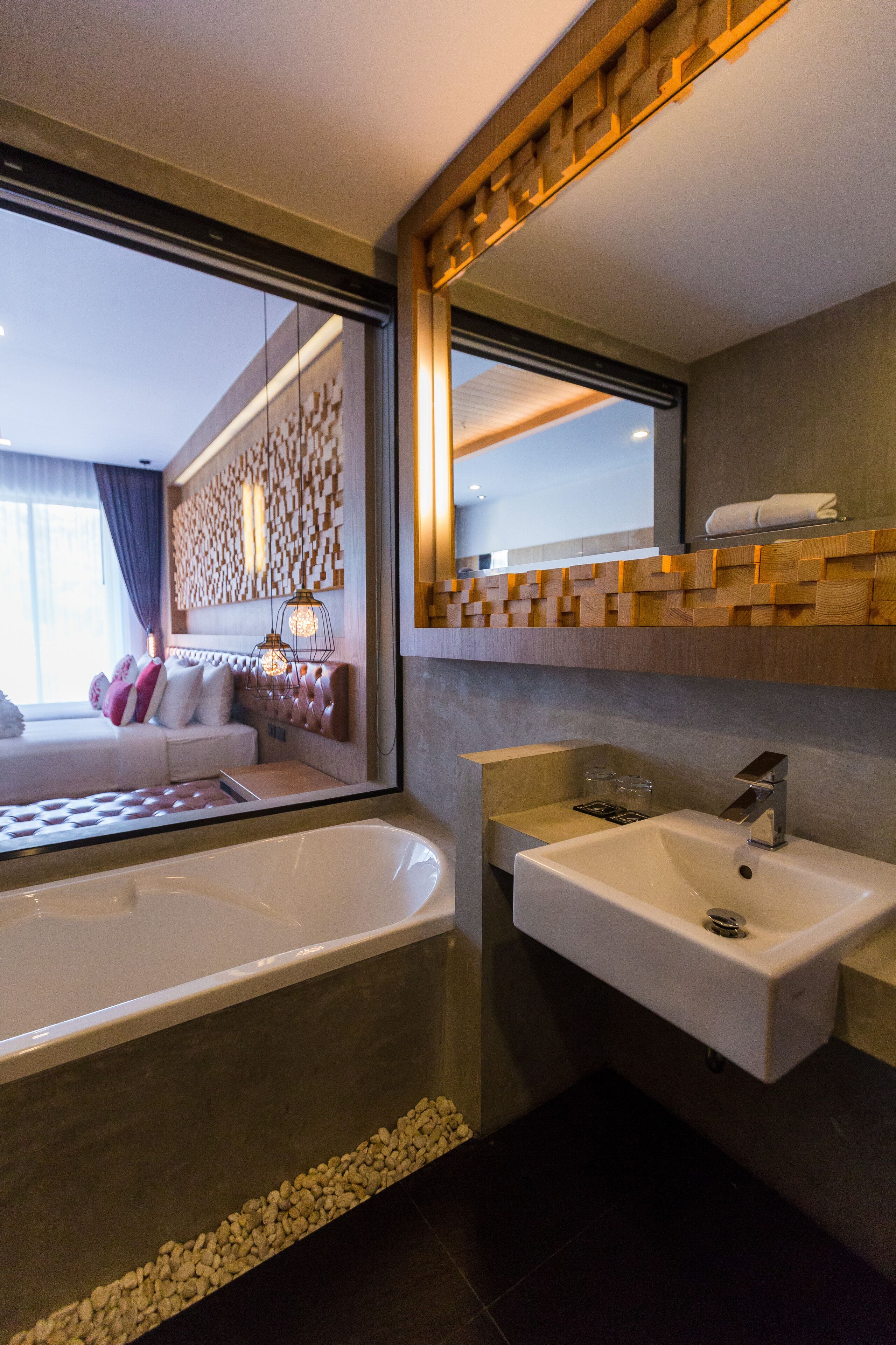 Une salle de bain moderne avec une baignoire, un lavabo et un grand miroir.