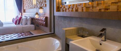 Une salle de bain moderne avec une baignoire, un lavabo et un grand miroir.