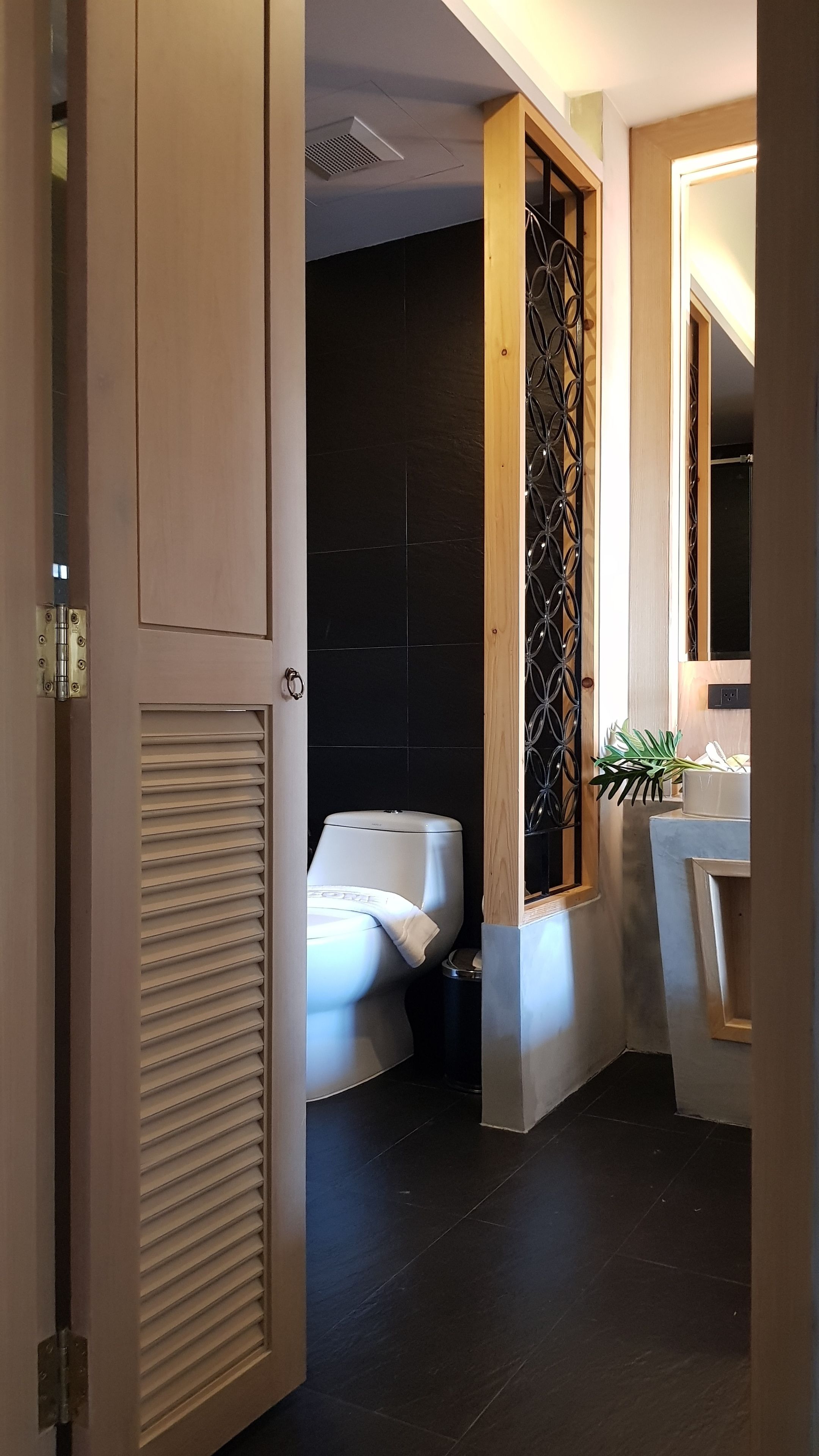 Une salle de bain moderne équipée de toilettes, d’une poubelle et d’un lavabo.