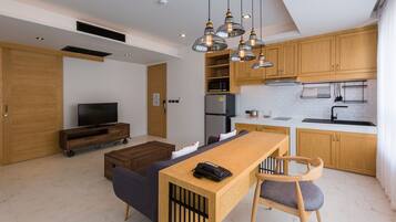 A modern kitchen with wooden cabinets, a built-in microwave, and a stainless steel refrigerator.