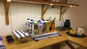 A kitchen counter with various items including milk cartons, a coffee maker, and a pumpkin.