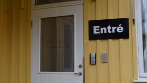 A hotel entrance with a door labeled "HOTEL HÅSSLÖ" and an "Entré" sign.