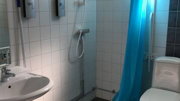 A bathroom with a shower, toilet, and sink.