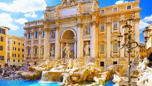 A grand building with classical architecture, a central fountain, and a crowd of people. - Via Veneto Luxury Suites (Rome)