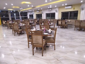 Un comedor amplio con varias mesas y sillas dispuestas en un patrón de cuadrícula.