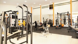 A gym with various exercise machines, a weight bench, and a wall-mounted air conditioning unit. -  Maper Mardan - Beira Rio (Parauapebas)