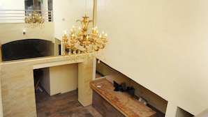 Um banheiro com espelho grande, lustre, banheira e toucador com espelho.