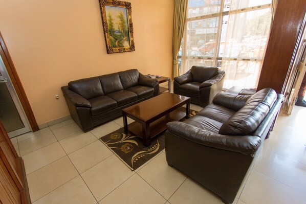 A living room with a sofa set, a coffee table, and a painting on the wall.