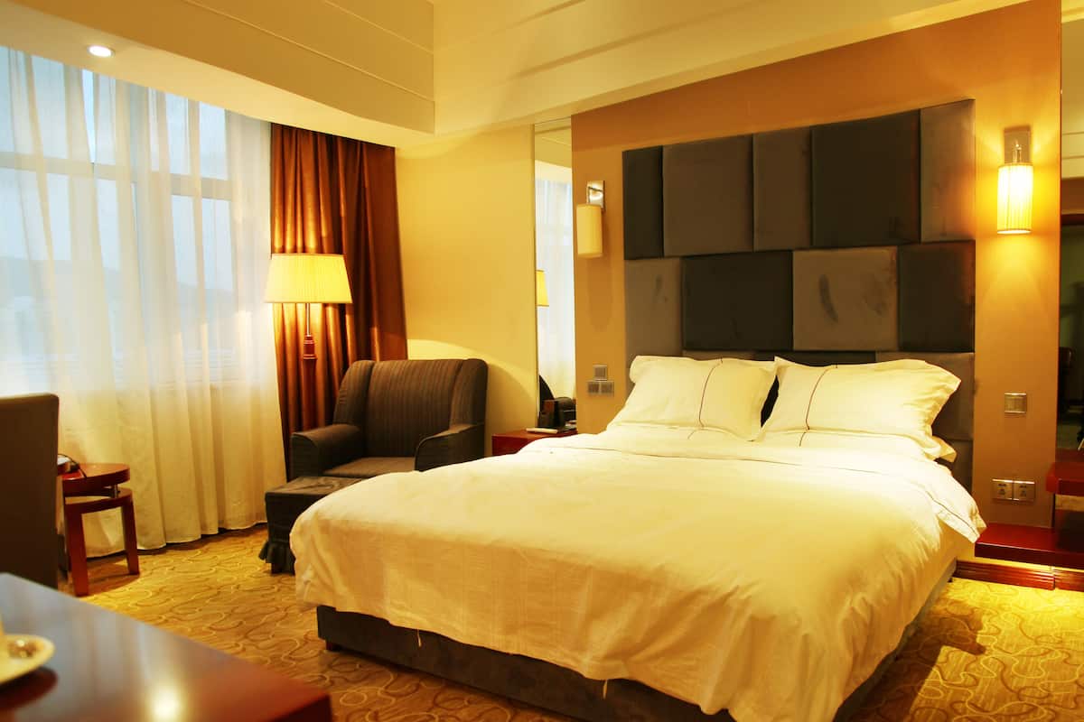 Minibar, escritorio, cortinas blackout y tabla de planchar con plancha