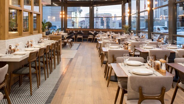 A restaurant with multiple dining tables and chairs, large windows, and a view of the cityscape. - Park Inn by Radisson Istanbul Atasehir (Istanbul)