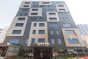 A modern hotel with a 'park inn by Radisson' sign, featuring a geometric facade, large windows, and a gated entrance. - Park Inn by Radisson Istanbul Atasehir (Istanbul)