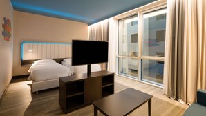 A modern hotel room with a large bed, a flat-screen TV, a wooden coffee table, and a large window with curtains. - Park Inn by Radisson Istanbul Atasehir (Istanbul)