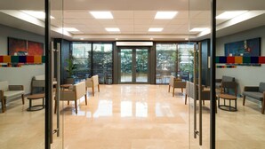 A spacious lobby with a glass partition, comfortable seating, and large windows offering a view of the outdoors. - Park Inn by Radisson Istanbul Atasehir (Istanbul)