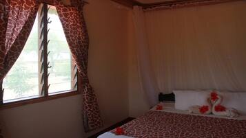 Un dormitorio con cama, cortinas y ventana.