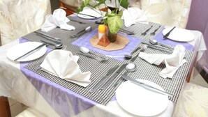 A dining table set with plates, cutlery, and a centerpiece.