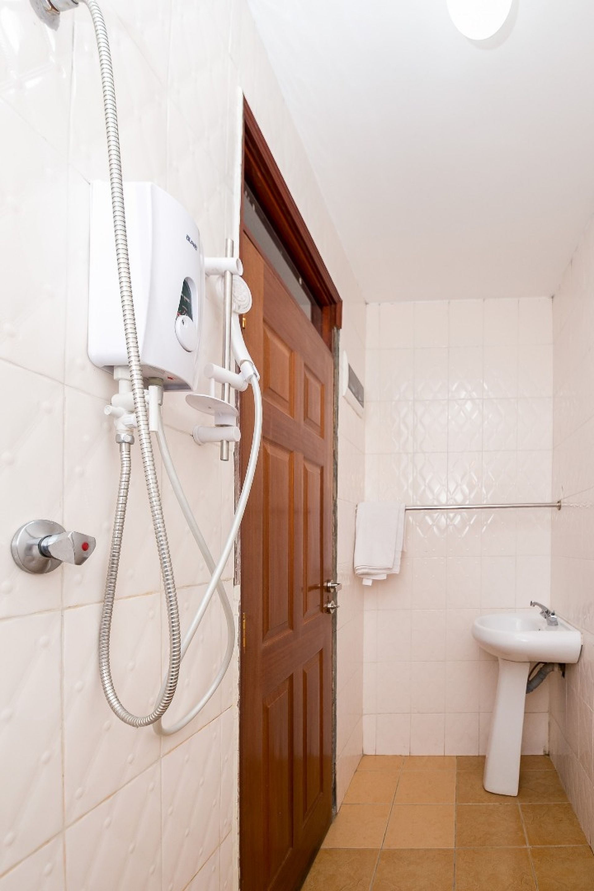 A bathroom with a shower, a sink, and a towel rack.