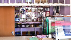 A bar with shelves of bottled beverages and a coffee machine. - Maru B Courts Hotel (Nyeri)