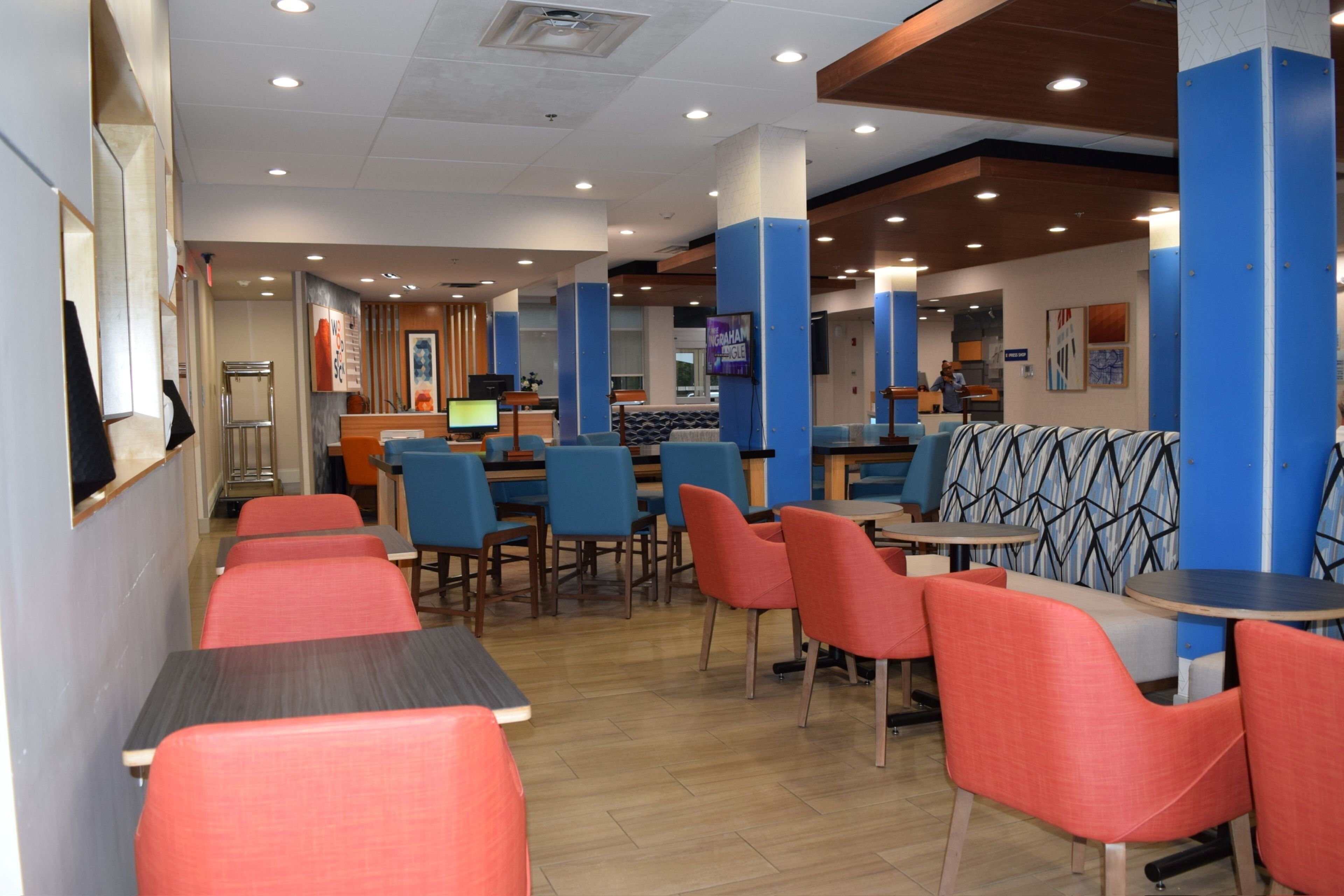 A restaurant with booths and tables, a counter, and a television screen.