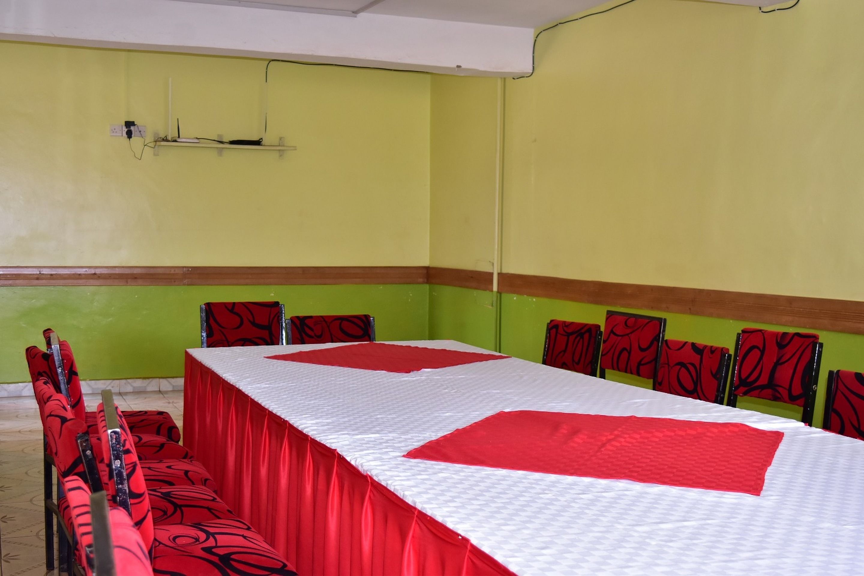 A conference room with a long table, red and white tablecloth, and matching chairs.