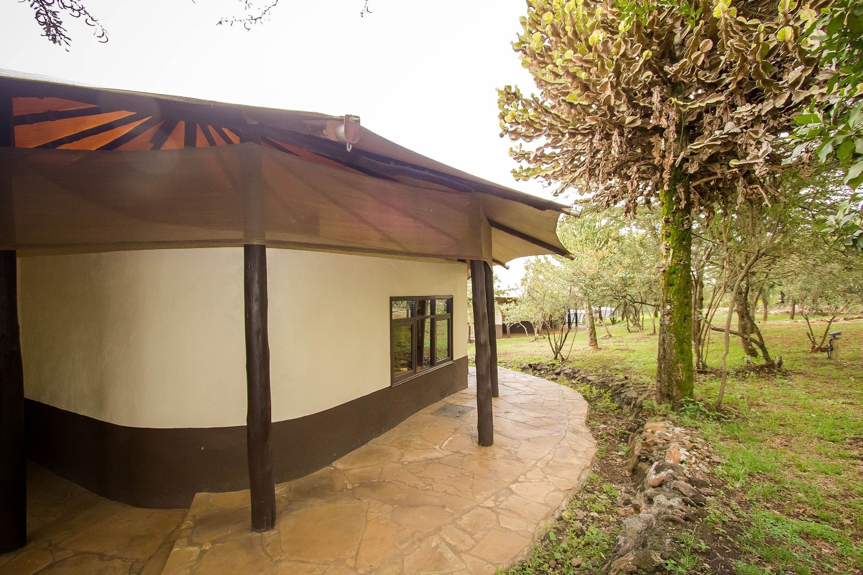 A building with a stone-paved entrance and a covered patio area.