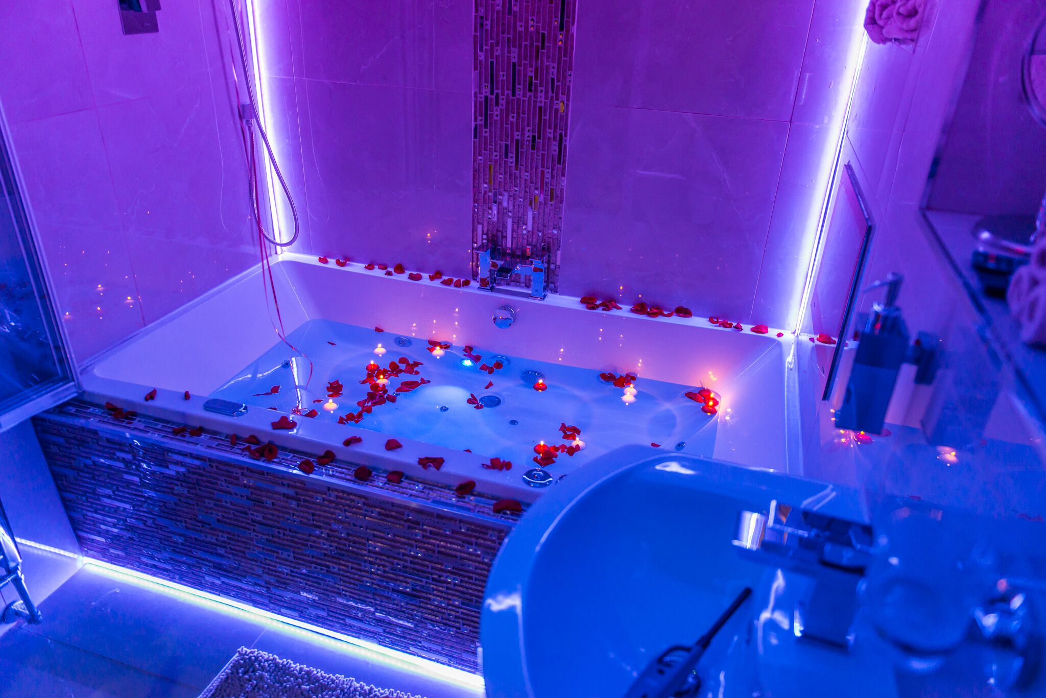 Une salle de bain moderne dotée d’une grande baignoire, d’une douche en verre et d’un système de filtration de l’eau visible.