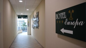 A hotel corridor with directional signs to the hotel and Europa. - Hotel Europa (Biella)