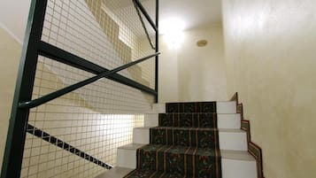 Una escalera con alfombra estampada y barandilla de metal.