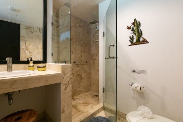 A bathroom with a marble sink, a glass-enclosed shower, and a toilet. - Bosque de los Aluxes Condos with private pool by PPR (Playa del Carmen)