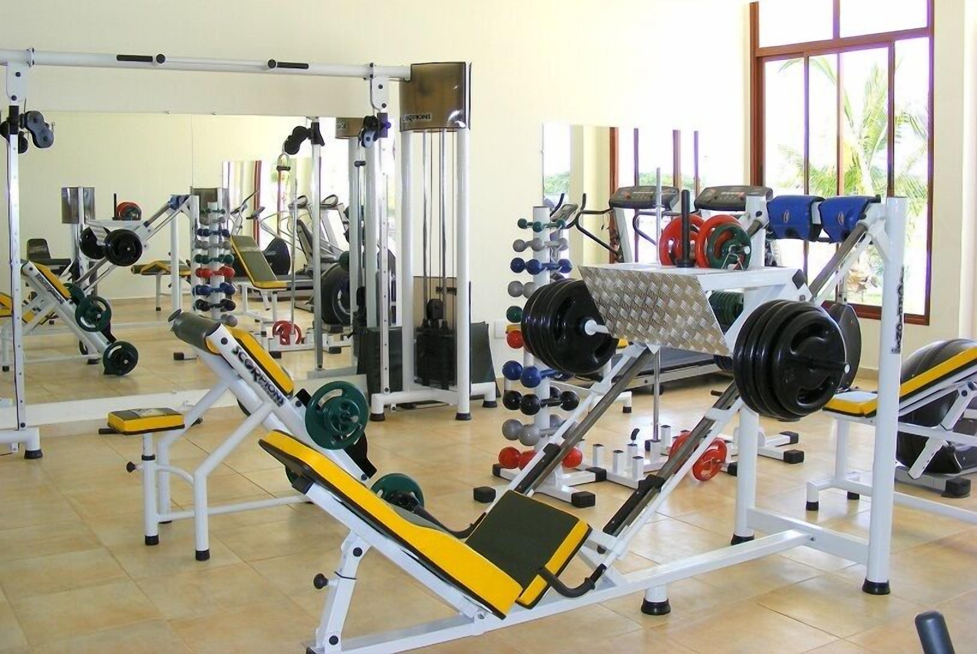 A gym with various exercise equipment, including weight machines and free weights.