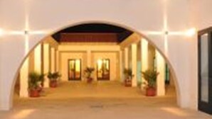An arched corridor with potted plants, leading to a building entrance. - Blumare Hotel & Residence (Otranto)