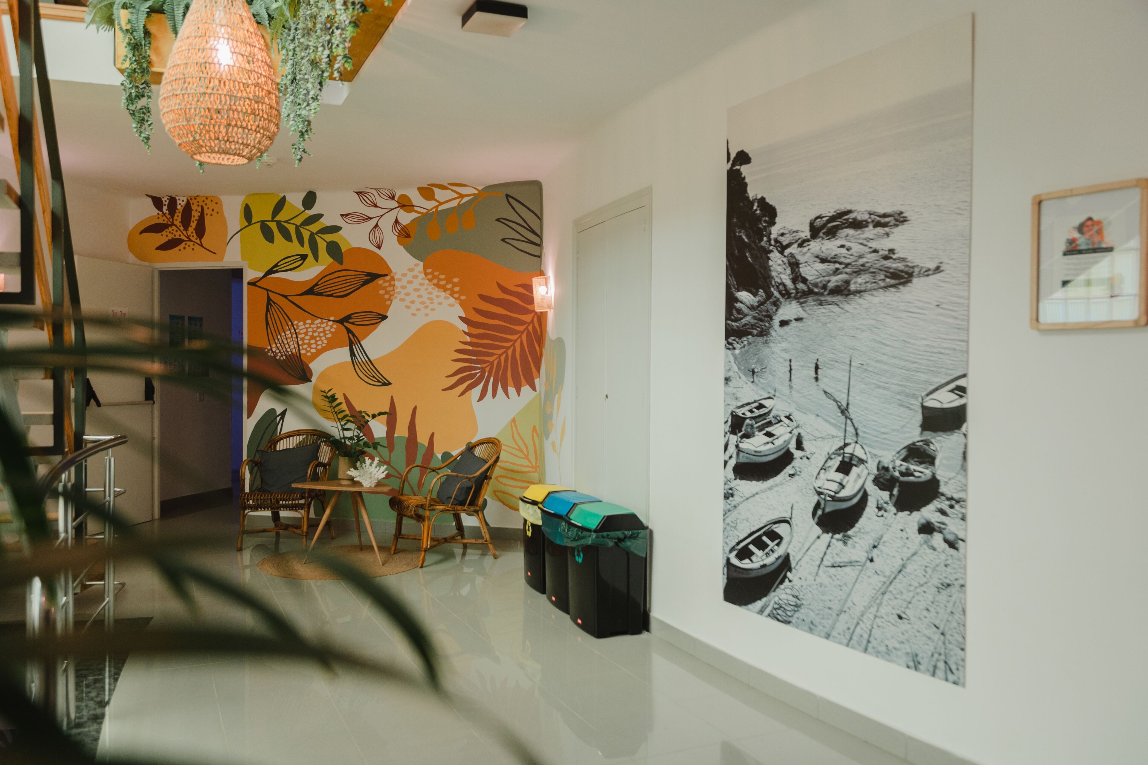 A modern interior with a dining area, a mural, and a large black and white photograph on the wall.