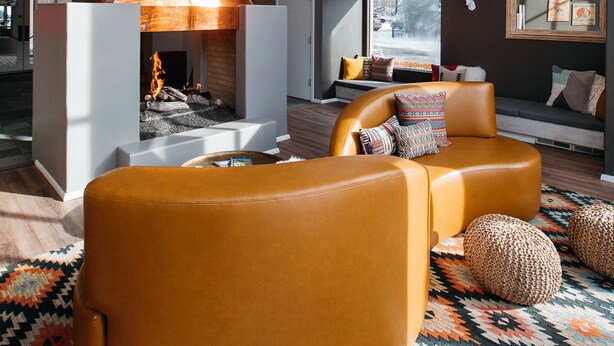 A modern interior with a fireplace, leather seating, and hanging spherical lights. - Hotel Ketchum (Ketchum)