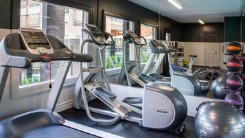 A gym with treadmills, ellipticals, and exercise balls.