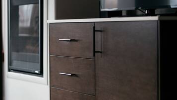 Una cocina moderna con horno empotrado y un mueble de madera oscura con cajones.
