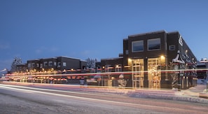 A modern building with multiple windows and a flat roof, surrounded by snow-covered ground.
