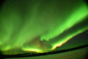 Nattehimmel med synlige stjerner og nordlys.
