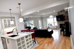 Habitación presidencial, 2 camas de matrimonio | Sala de estar | Televisión LED de 65 pulgadas con canales por cable, una televisión