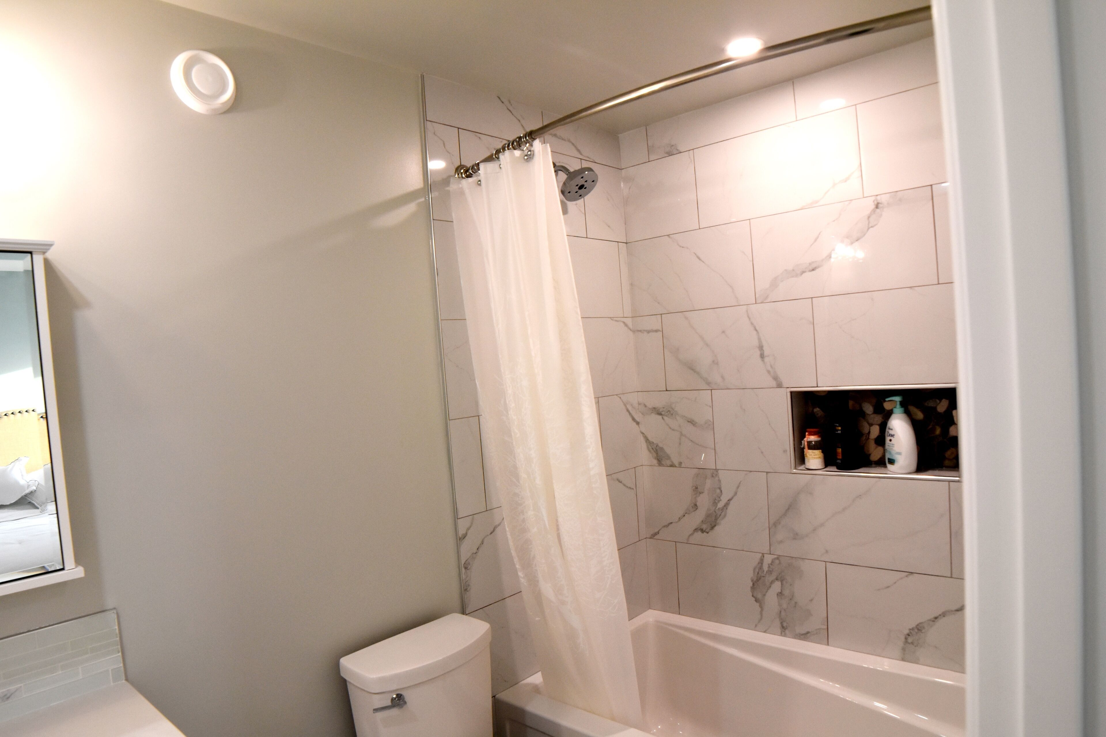 Un bagno con doccia, WC e pareti piastrellate in marmo.