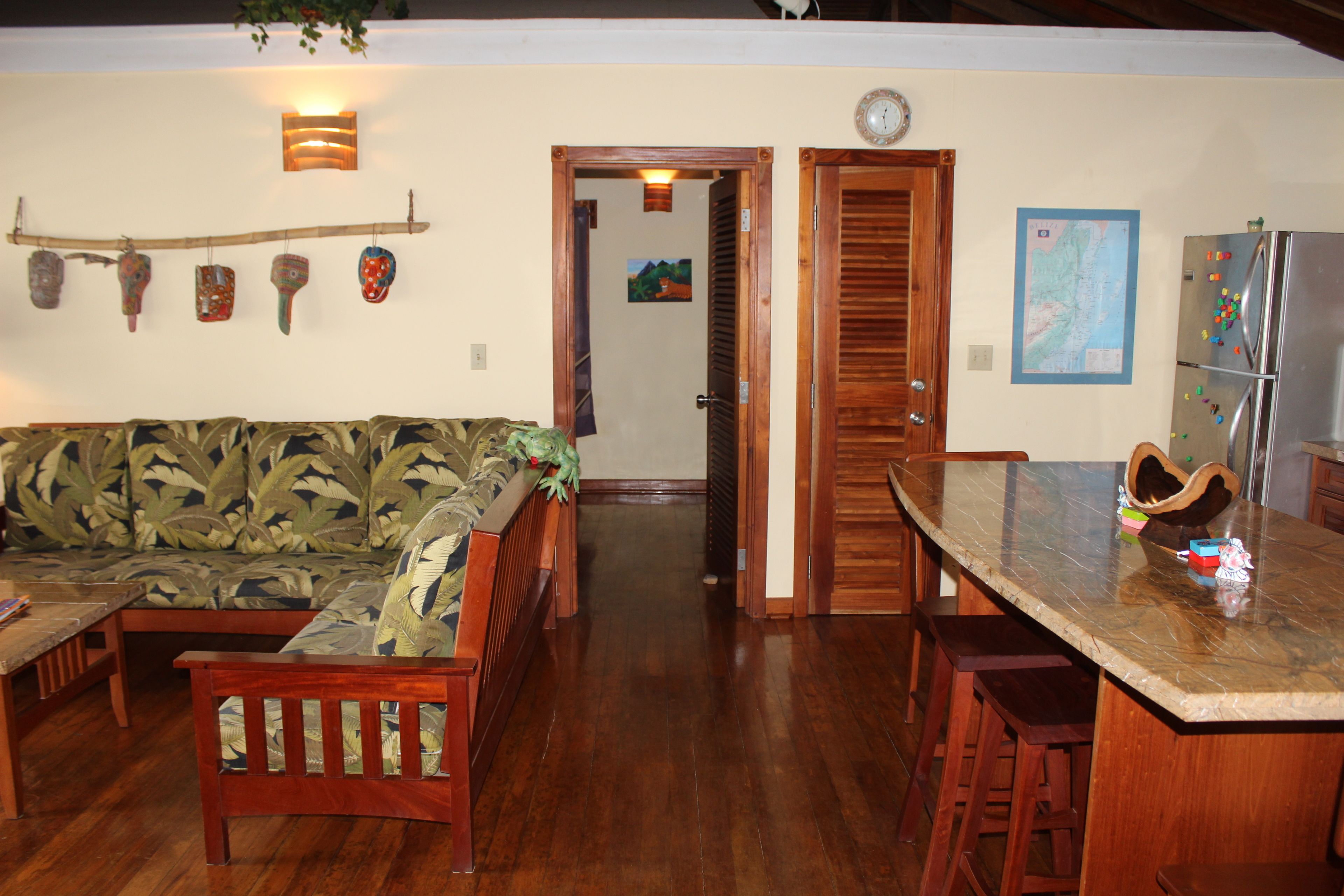 A kitchen with a wooden table and chairs, a refrigerator, and a dining area.