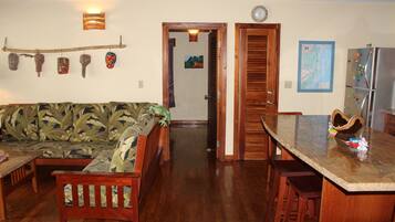 A kitchen with a wooden table and chairs, a refrigerator, and a dining area.