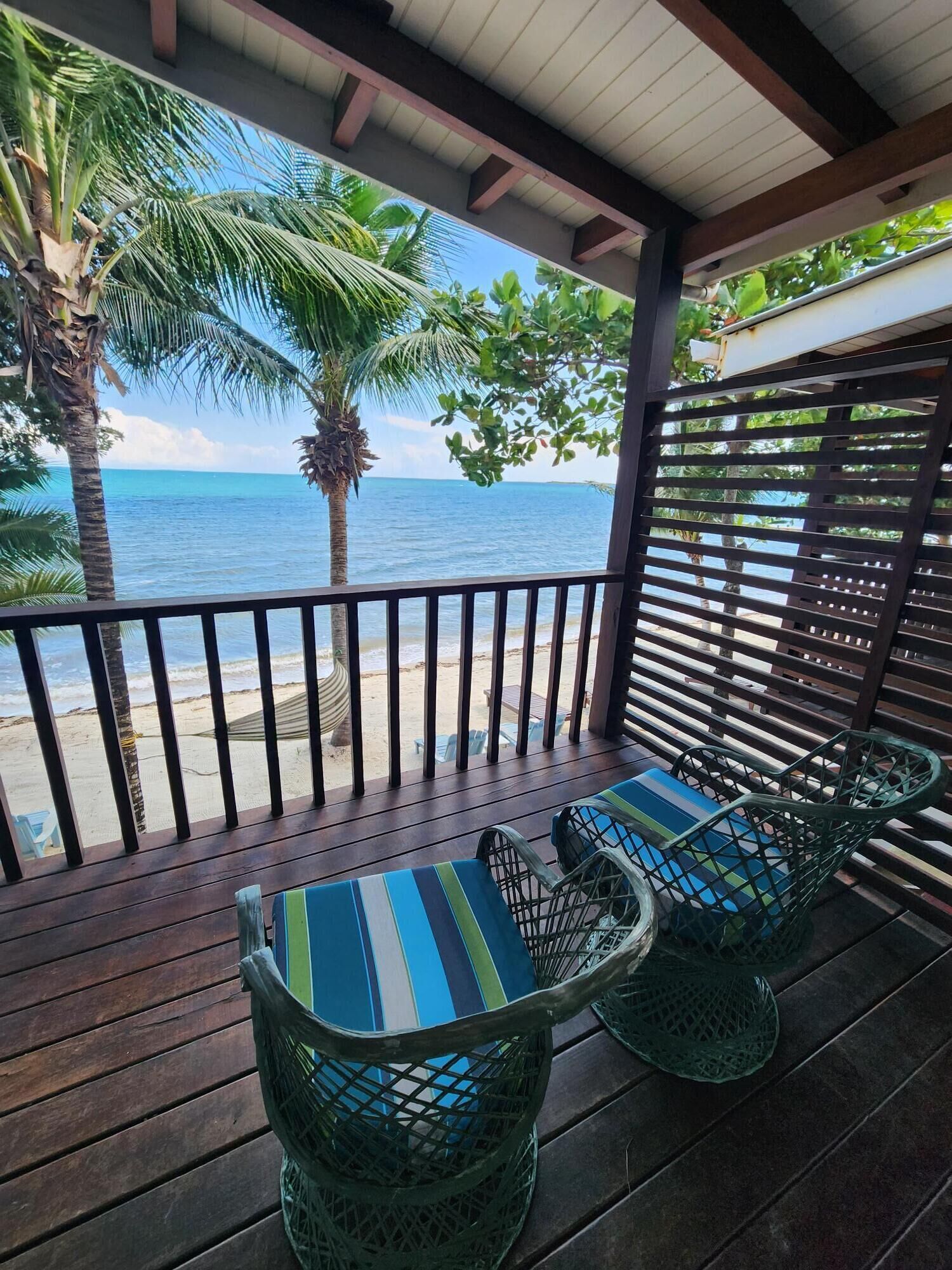 Un espacio de estar al aire libre techado con vista a la playa y al océano.