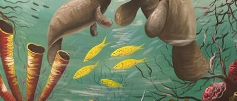 An underwater scene with manatees, fish, and coral.