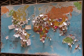 A world map covered with various papers and notes.