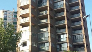 Un edificio residencial de varios pisos con balcones y ventanas amplias.