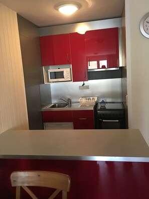 Frigorífico, microondas, placa de cocina y utensilios de cocina