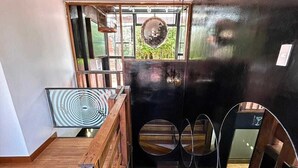 Een moderne trap met een houten leuning en een zwarte muur met ronde spiegels.