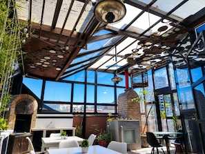 An indoor space with a glass ceiling, brick oven, and seating area. - Dolce Lobo Boutique Stay (Quito)