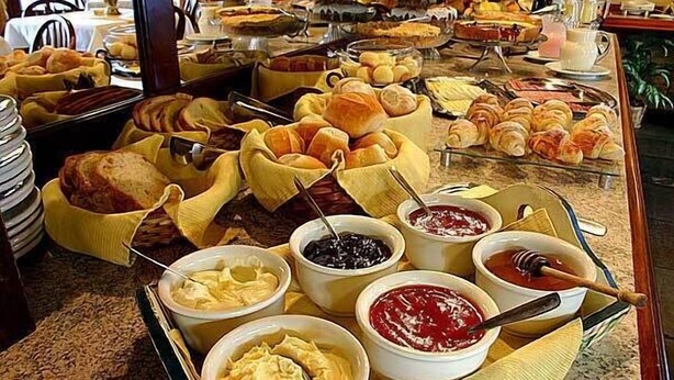 A buffet with various breads, pastries, and spreads. - Pousada do Bosque (Canela)