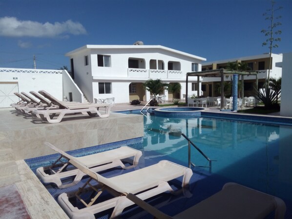 Alberca al aire libre y camastros